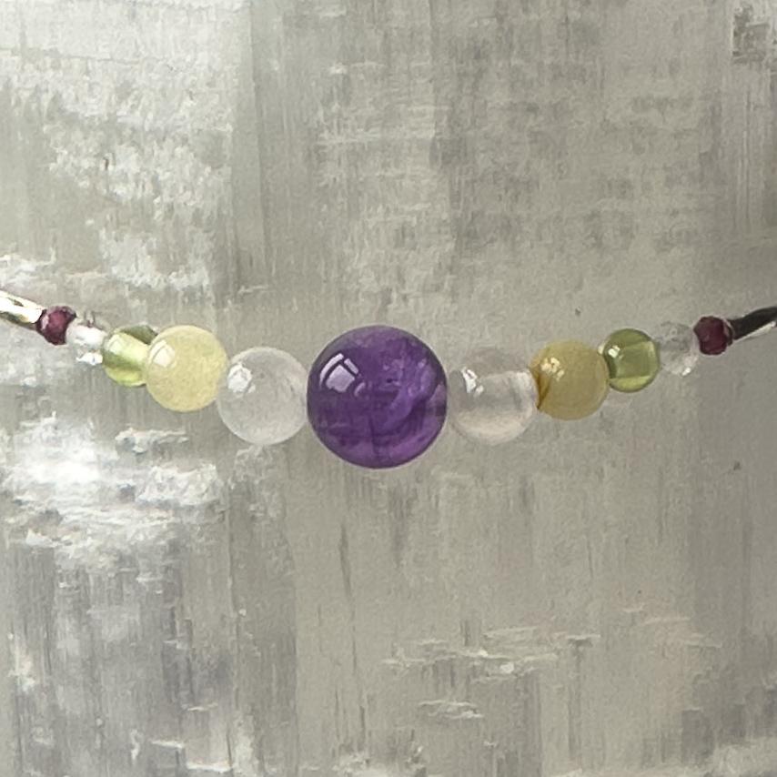 Scorpio Birthstone Healing Crystal bracelet for Determination & Willpower showing Amethyst, Garnet, Aragonite, Peridot, Selenite and Clear Quartz