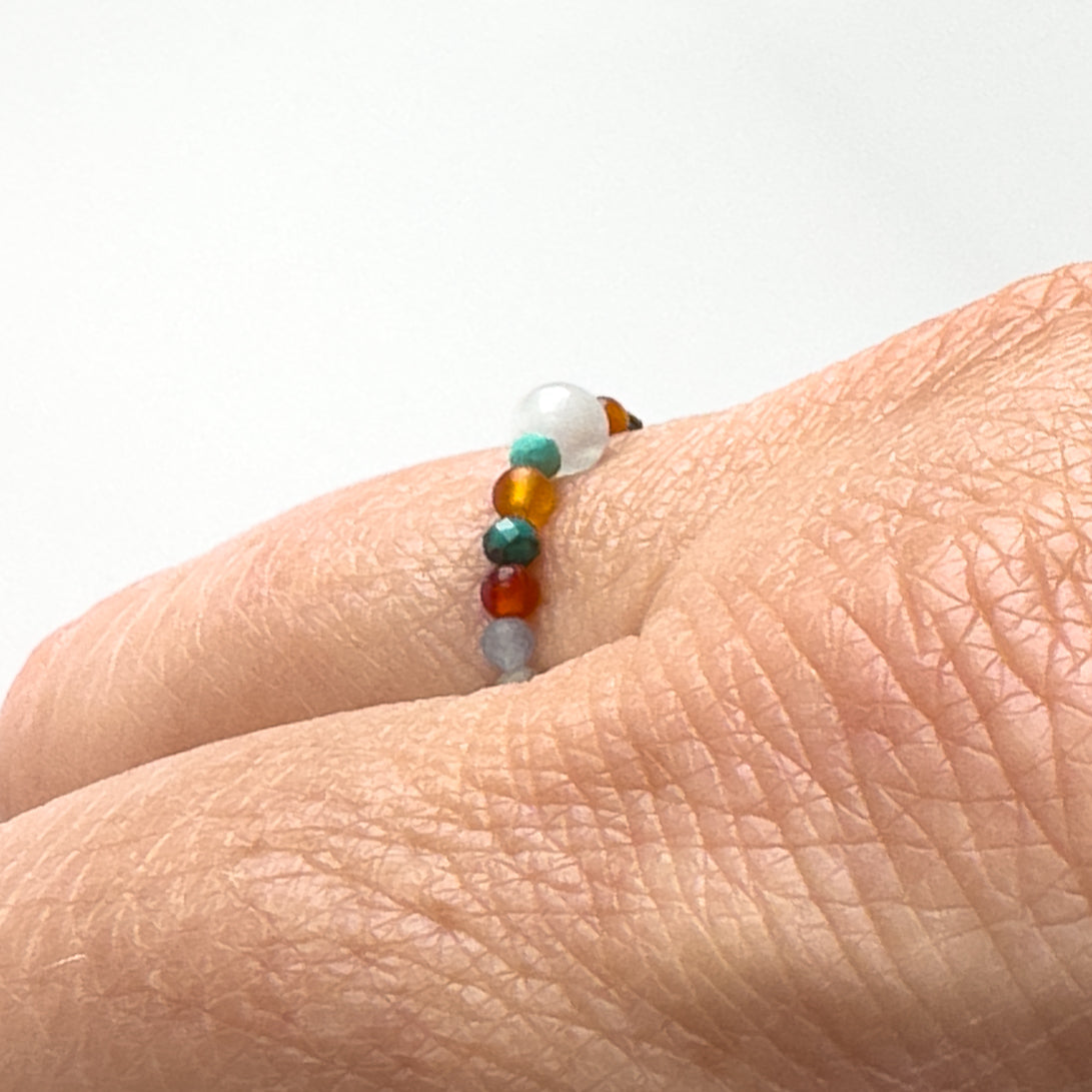 Side view of Cancer Birthstone Healing Crystal ring for Strength and Courage on a finger