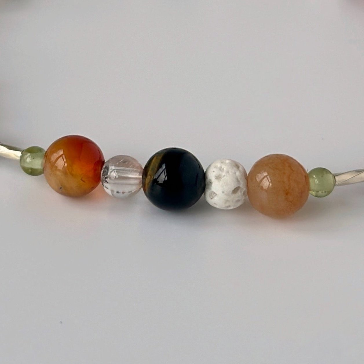 Taurus birthstone Healing Crystal bracelet for Determination & Willpower showing Peridot, Carnelian, Blue Tiger’s Eye, Lava Stone and Clear Quartz