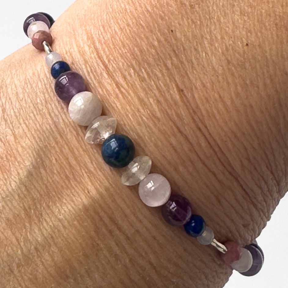 Taurus Healing Crystal bracelet for Anxiety on wrist showing Amethyst, Lapis Lazuli, Blue Lace Agate, Rhodonite, Rose Quartz, Kunzite, Azurite and Clear Quartz