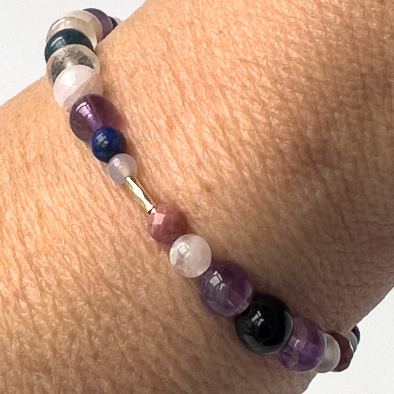 Taurus Birthstone Healing Crystal bracelet for Calm & Anxiety Relief on wrist showing Amethyst, Lapis Lazuli, Blue Lace Agate, Rhodonite, Kunzite, and Blue Tiger’s Eye