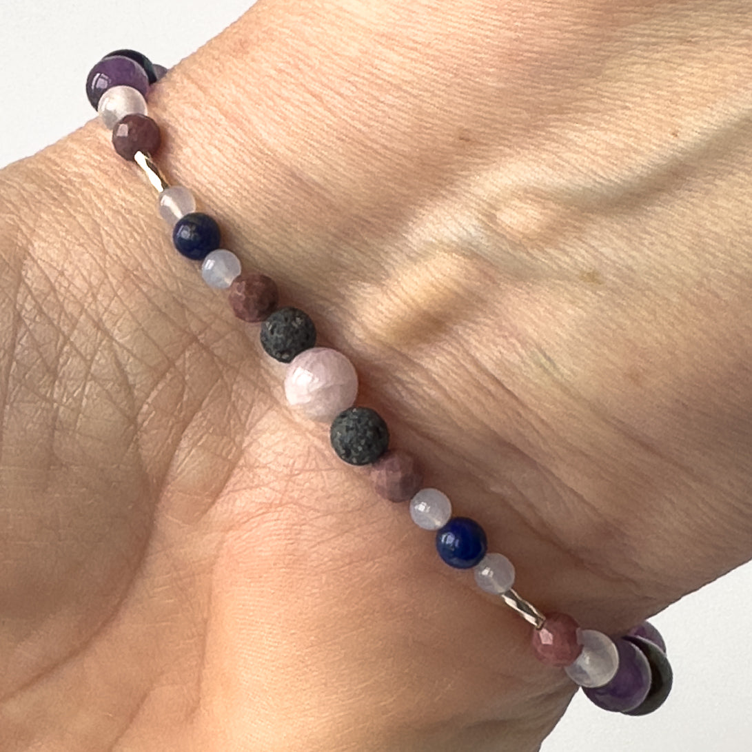 Taurus Birthstone Healing Crystal bracelet for Calm & Anxiety Relief on wrist showing Lapis Lazuli, Blue Lace Agate, Rhodonite, Kunzite and Lava