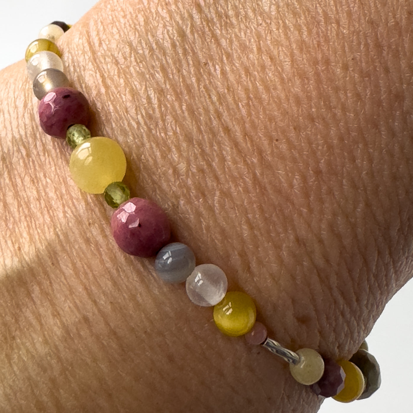 Taurus Healing Crystal bracelet for Confidence on wrist showing Yellow Tiger’s Eye, Aragonite, Botswana Agate, Peridot, Rhodonite and Selenite