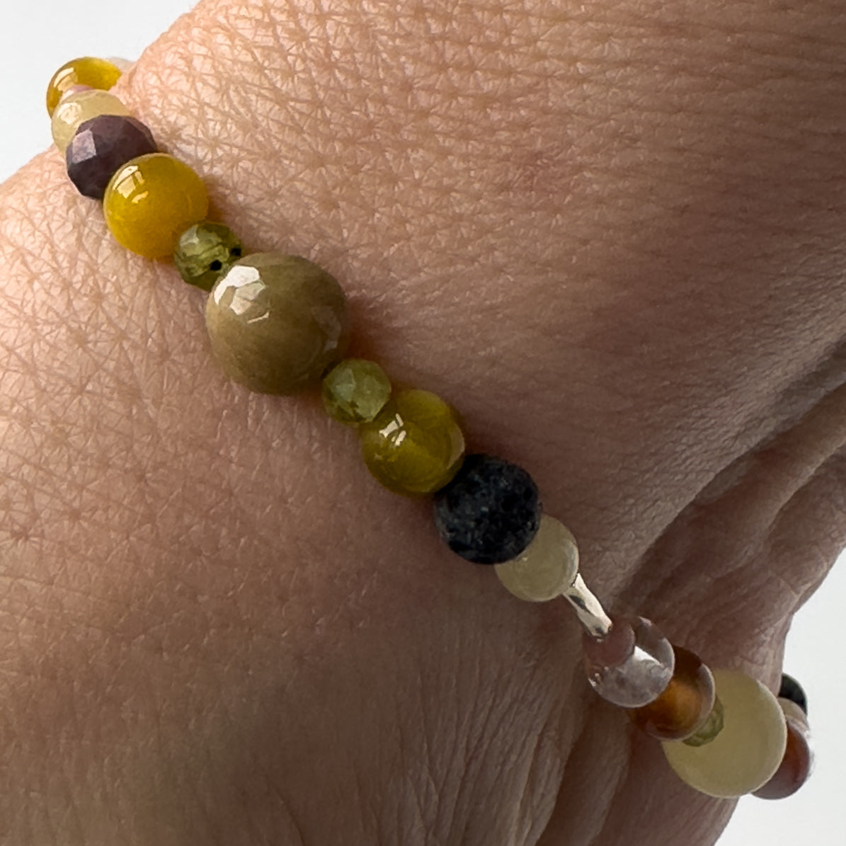 Taurus Birthstone Healing Crystal bracelet for Confidence and Self-esteem showing Yellow Tiger’s Eye, Aragonite, Botswana Agate, Peridot, Rhodonite, Clear Quartz and Lava Stone