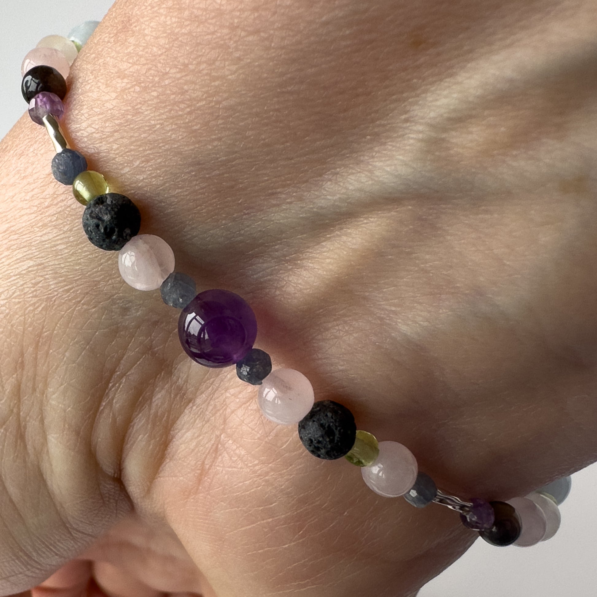 Taurus Birthstone Healing Crystal bracelet for Calm & Stress relief on wrist showing Amethyst, Peridot, Rose Quartz, Sapphire and Lava Stone