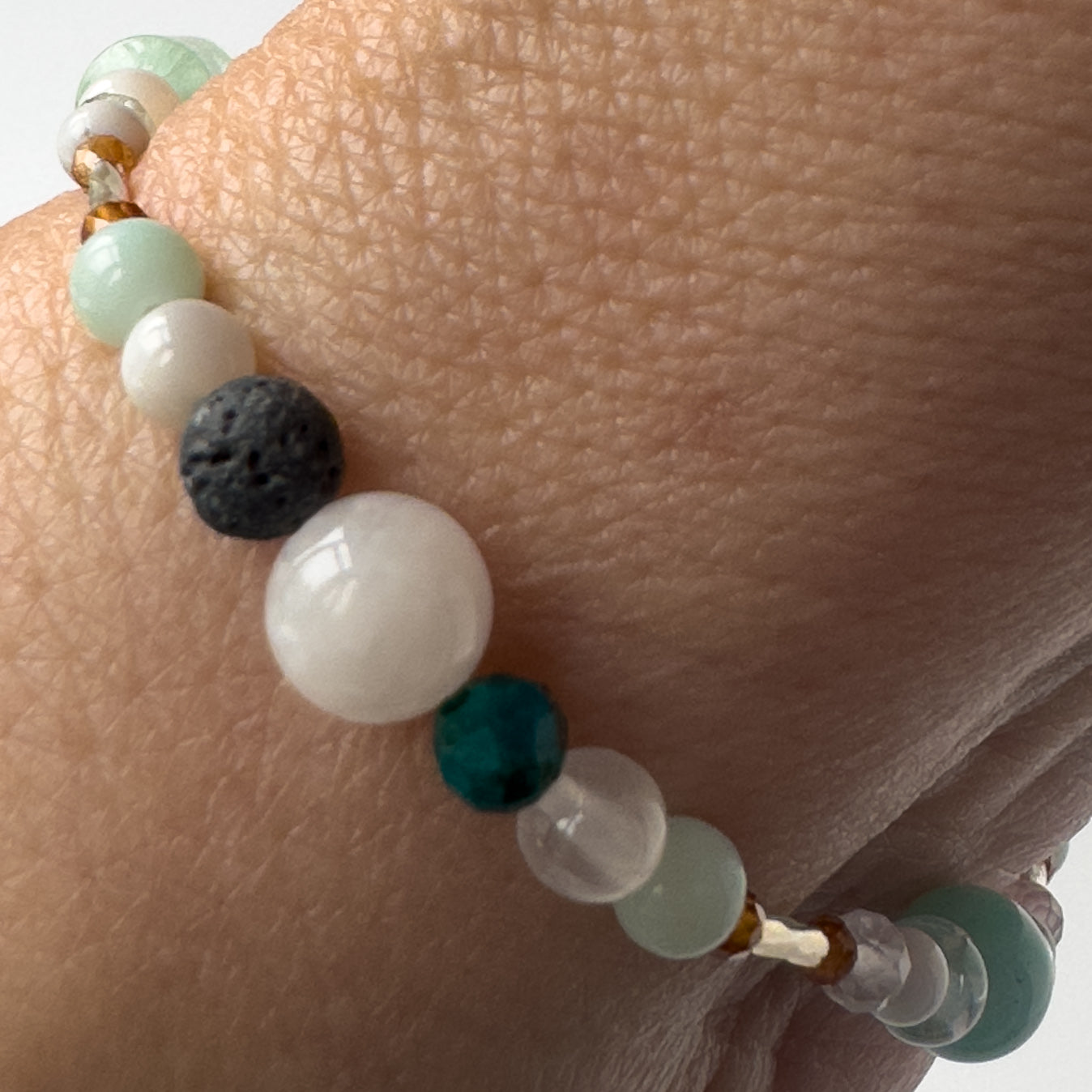 Virgo Birthstone Healing Crystal bracelet for Calm & Stress relief on wrist showing Moonstone, Amazonite, Garnet, Chrysocolla, Selenite and Lava Stone