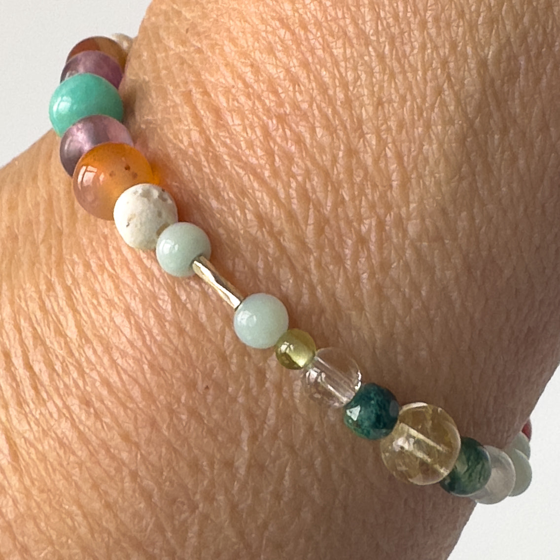 Virgo Birthstone Healing Crystal bracelet for Determination & Willpower on wrist showing Peridot, Sardonyx, Citrine, Amazonite, Chrysocolla, Clear Quartz and Lava Stone