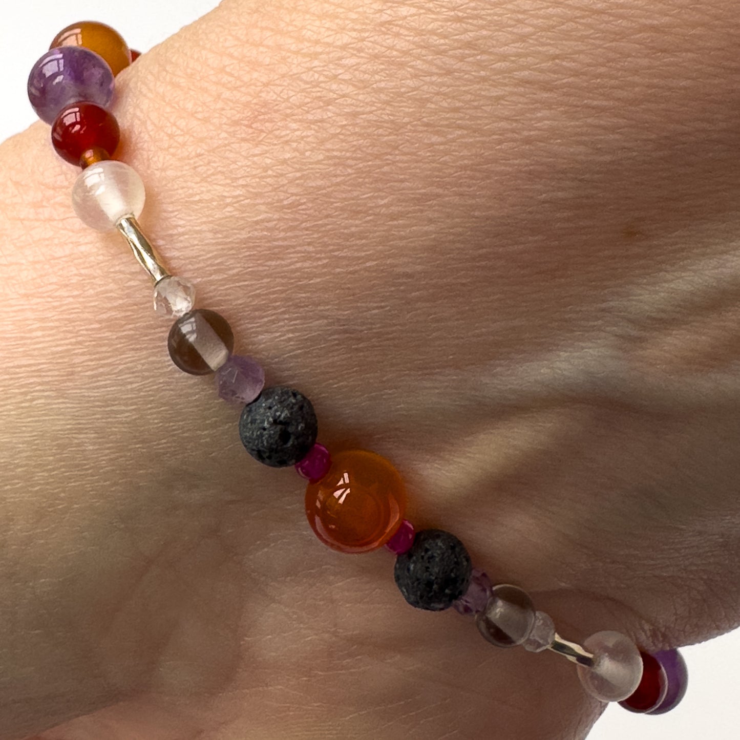 Aries Birthstone Healing Crystal bracelet for Grief & Loss support on wrist showing Amethyst, Ruby, Carnelian, Selenite and Lava Stone