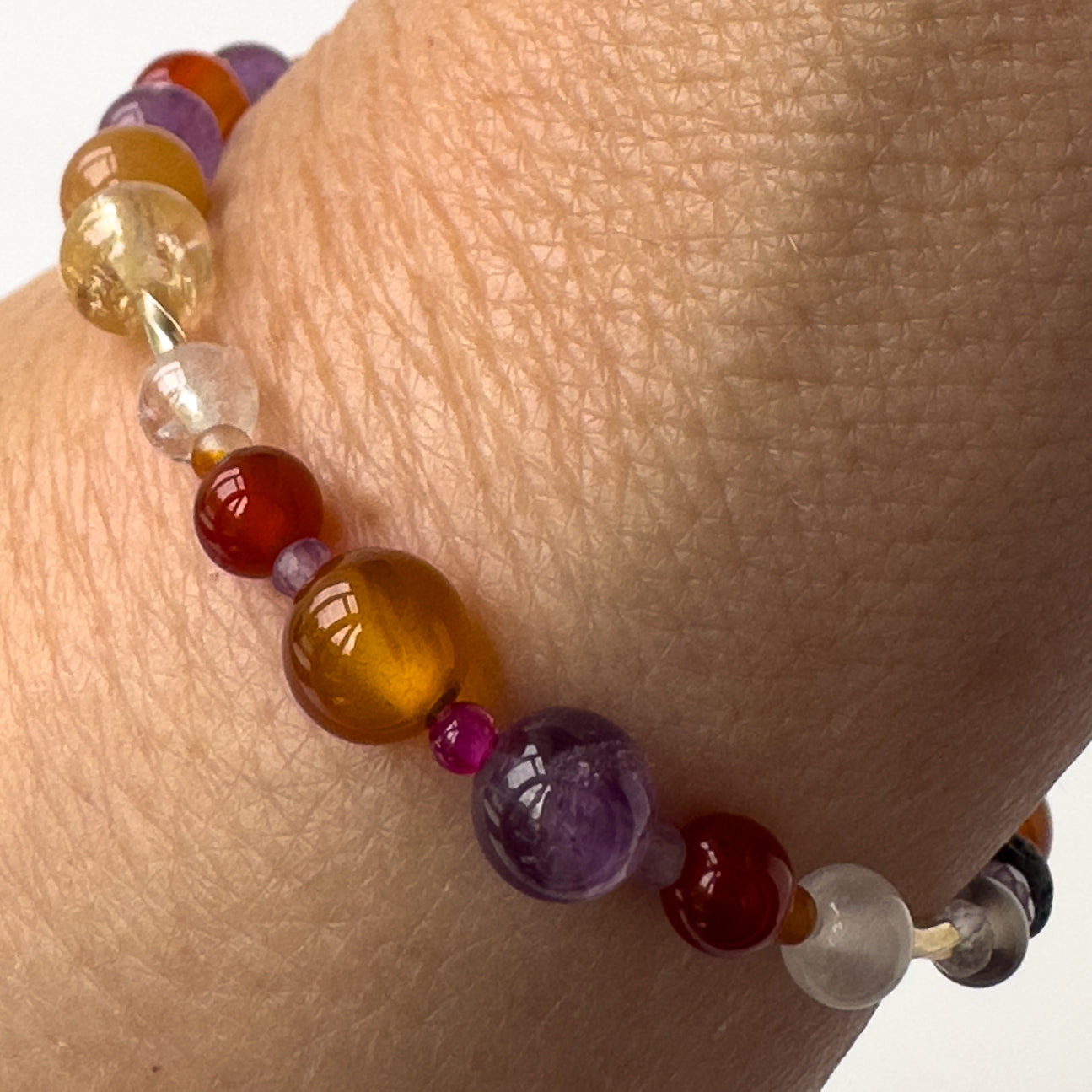 Aries birthstone Healing Crystal bracelet for Grief & Loss support on wrist showing Amethyst, Ruby, Citrine, Carnelian, Selenite and Clear Quartz