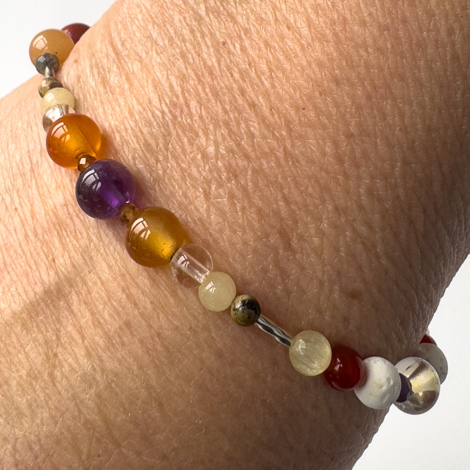 Aries Healing Crystal bracelet for Willpower on wrist showing Amethyst, Leopardskin Jasper, Aragonite, Garnet, Carnelian and Clear
