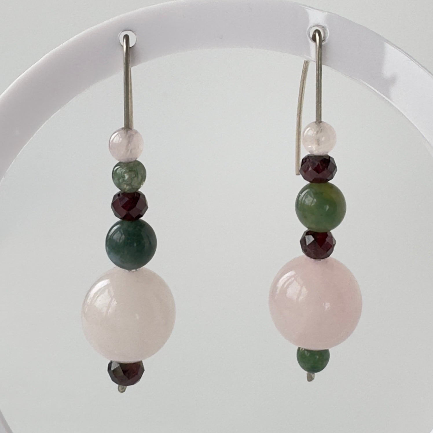 Beaded earrings with green, pink, and red beads on a white background