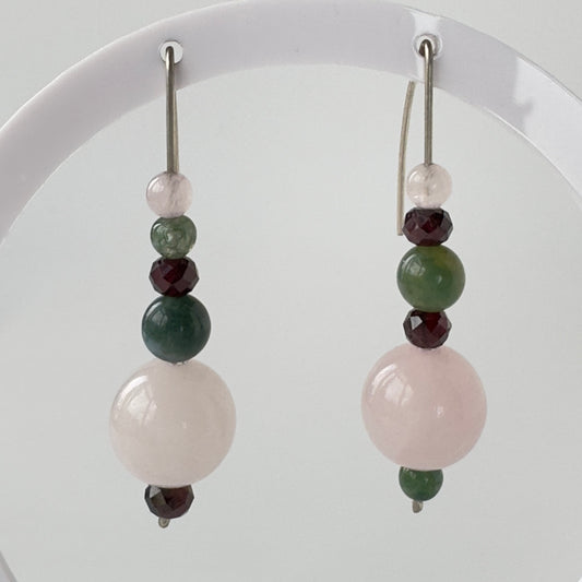 Beaded earrings with green, pink, and red beads on a white background