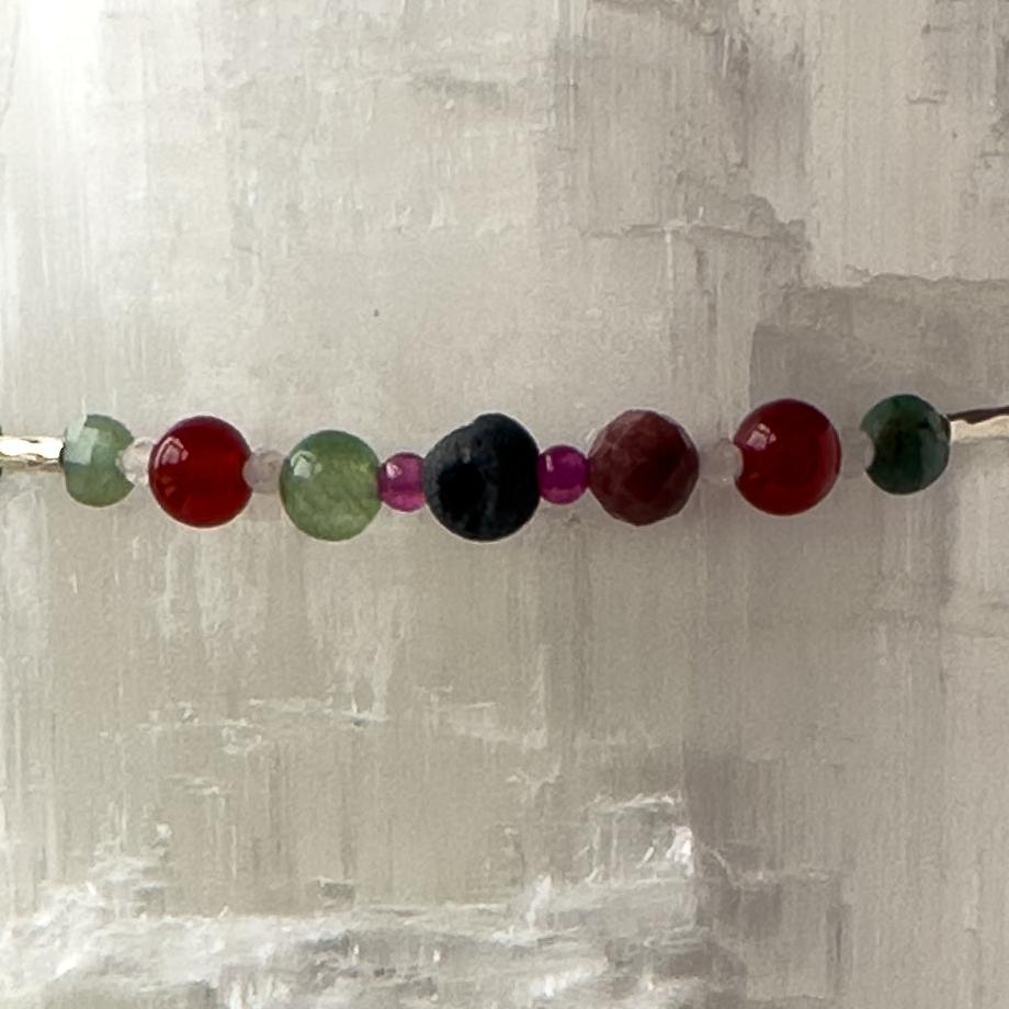 Cancer birthstone Healing Crystal bracelet for Grief & Loss support showing Ruby, Rhodonite, Carnelian, Rose Quartz, Chalcedony, Emerald and Lava Stone