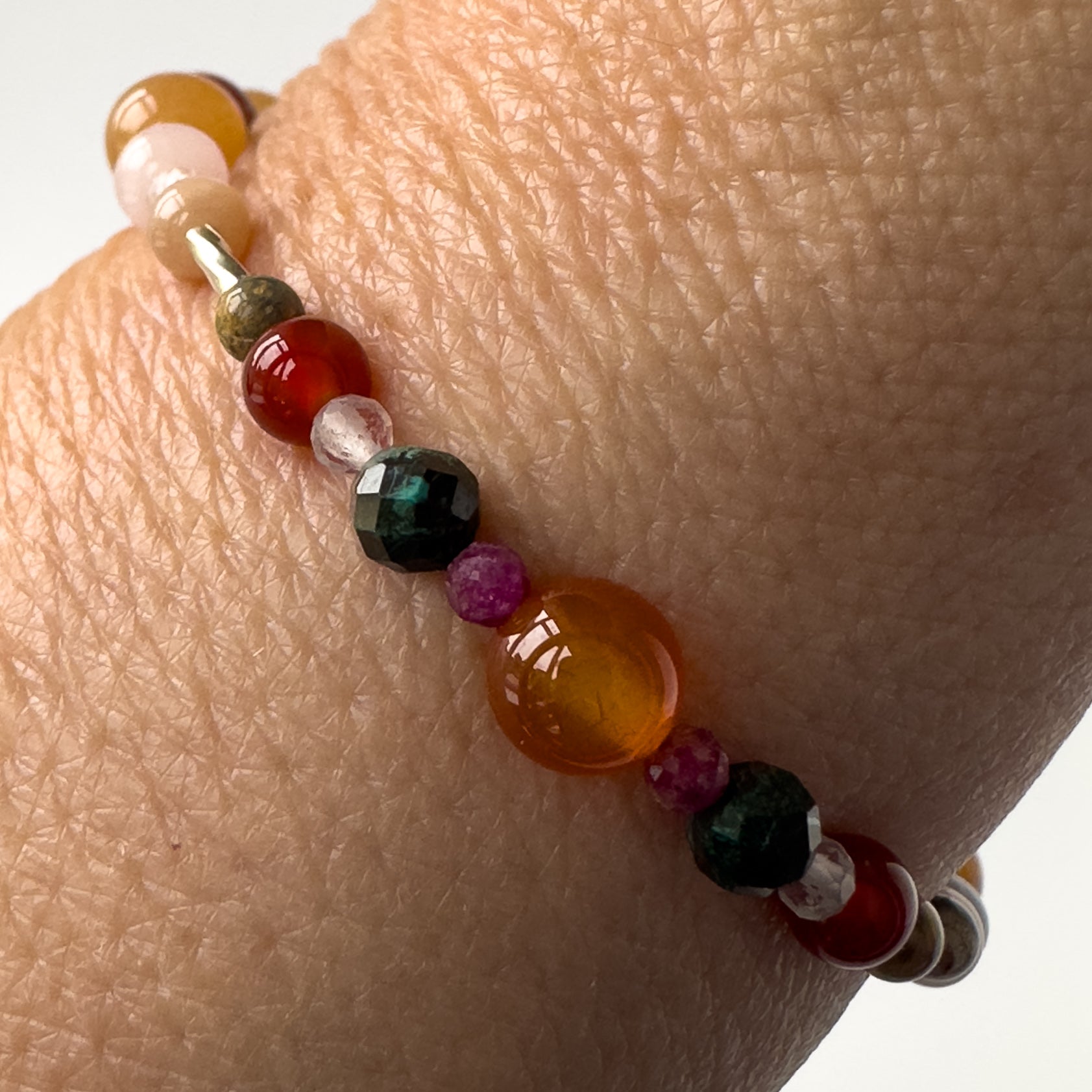 Cancer Healing Crystal bracelet for Willpower on wrist showing Ruby, Carnelian, Chrysocolla, Leopardskin Jasper and Clear Quartz