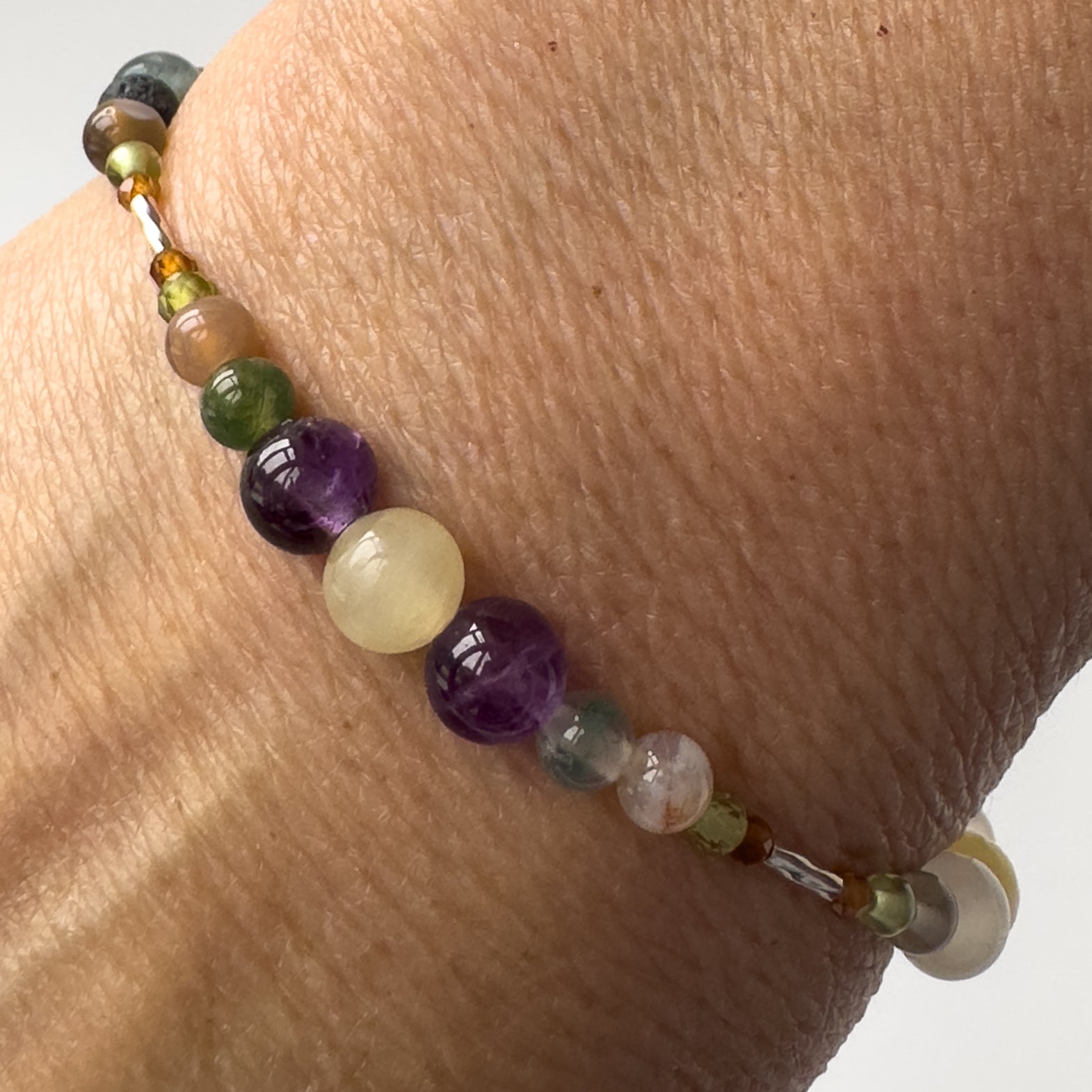 Capricorn Healing Crystal bracelet for Willpower on wrist showing Amethyst, Garnet, Botswana Agate, Moss Agate, Peridot and Aragonite