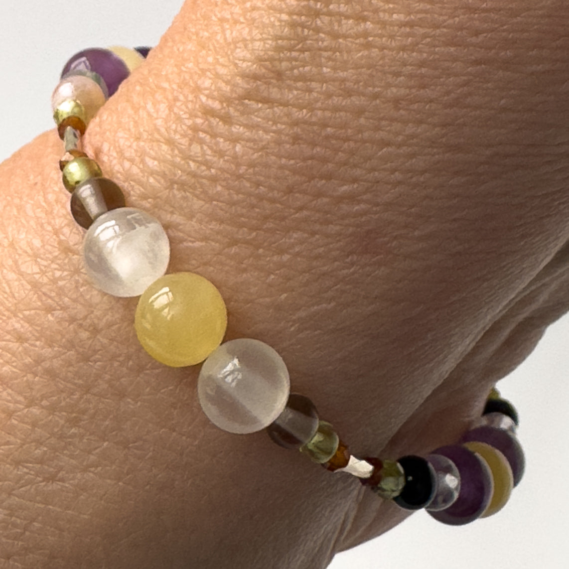 Capricorn Birthstone Healing Crystal bracelet for Determination & Willpower on wrist showing Garnet, Peridot, Smoky Quartz, Aragonite and Selenite
