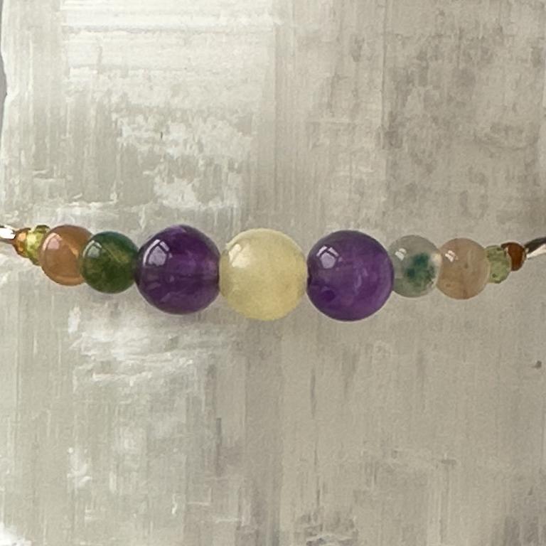 Capricorn Birthstone Healing Crystal bracelet for Determination & Willpower showing Amethyst, Garnet, Botswana Agate, Moss Agate, Peridot and Aragonite
