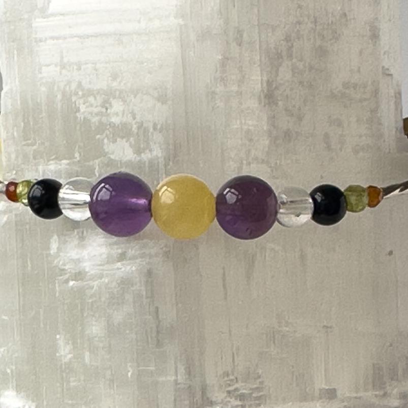 Capricorn Birthstone Healing Crystal bracelet for Determination & Willpower showing Onyx, Amethyst, Garnet, Peridot, Aragonite and Clear Quartz