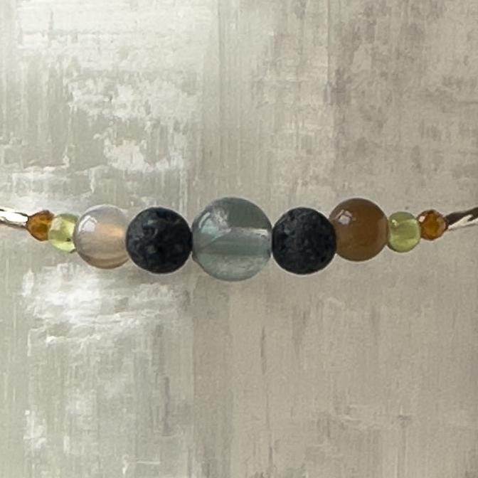 Capricorn Birthstone Healing Crystal bracelet for Determination & Willpower showing Rainbow Fluorite, Garnet, Botswana Agate, Peridot and Lava Stone