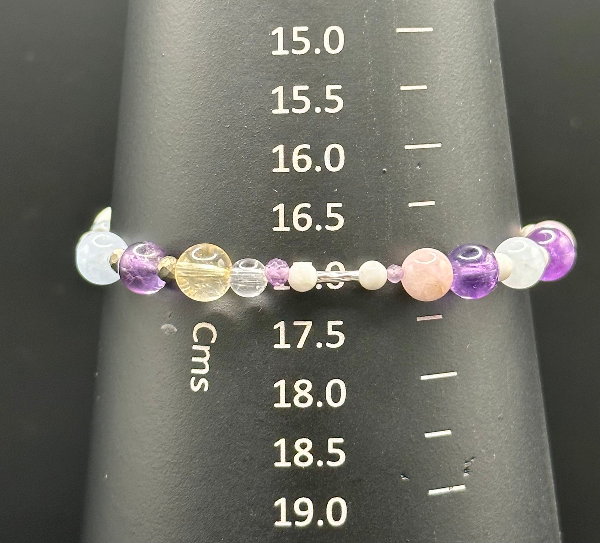 Close-up of Healing crystal bracelet showing Iron Pyrite, Amethyst, Kunzite, Citrine and Clear Quartz on a  bracelet mandrel showing size of 17cm