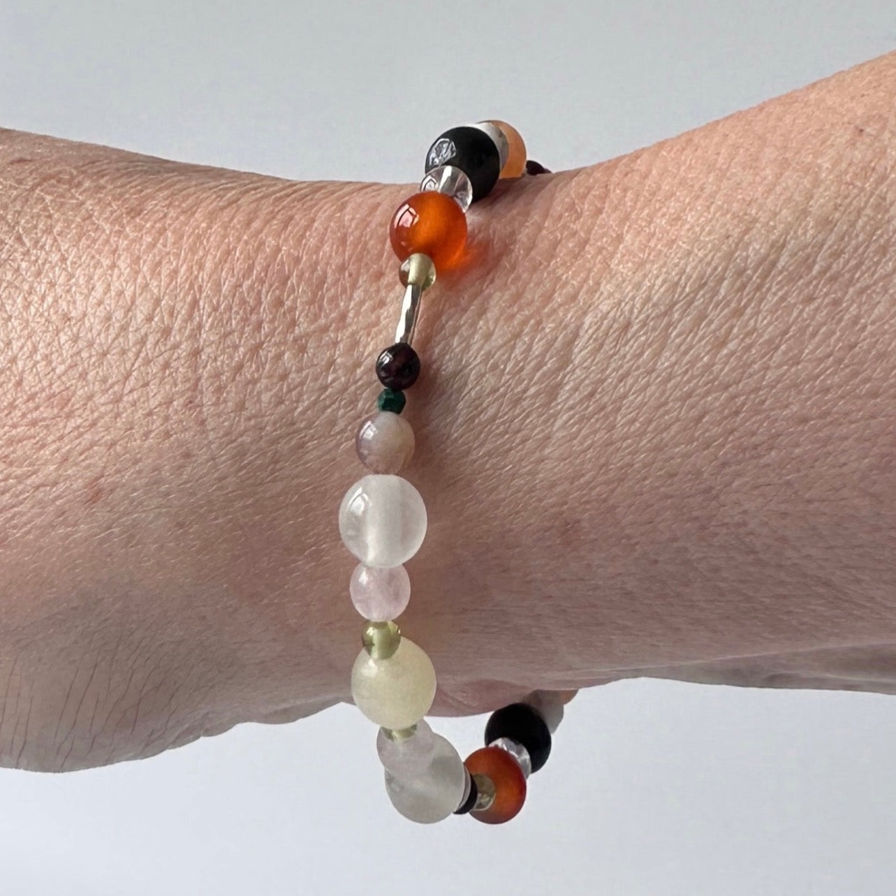 Taurus Handmade Healing Crystal bracelet for Willpower on wrist showing Peridot, Botswana Agate, Aragonite, Rose Quartz, Carnelian, Blue Tiger’s Eye, Red Tiger’s Eye