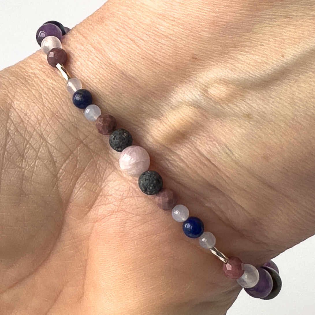 Taurus Healing Crystal bracelet for Anxiety on wrist showing Lapis Lazuli, Blue Lace Agate, Rhodonite, Kunzite and Lava