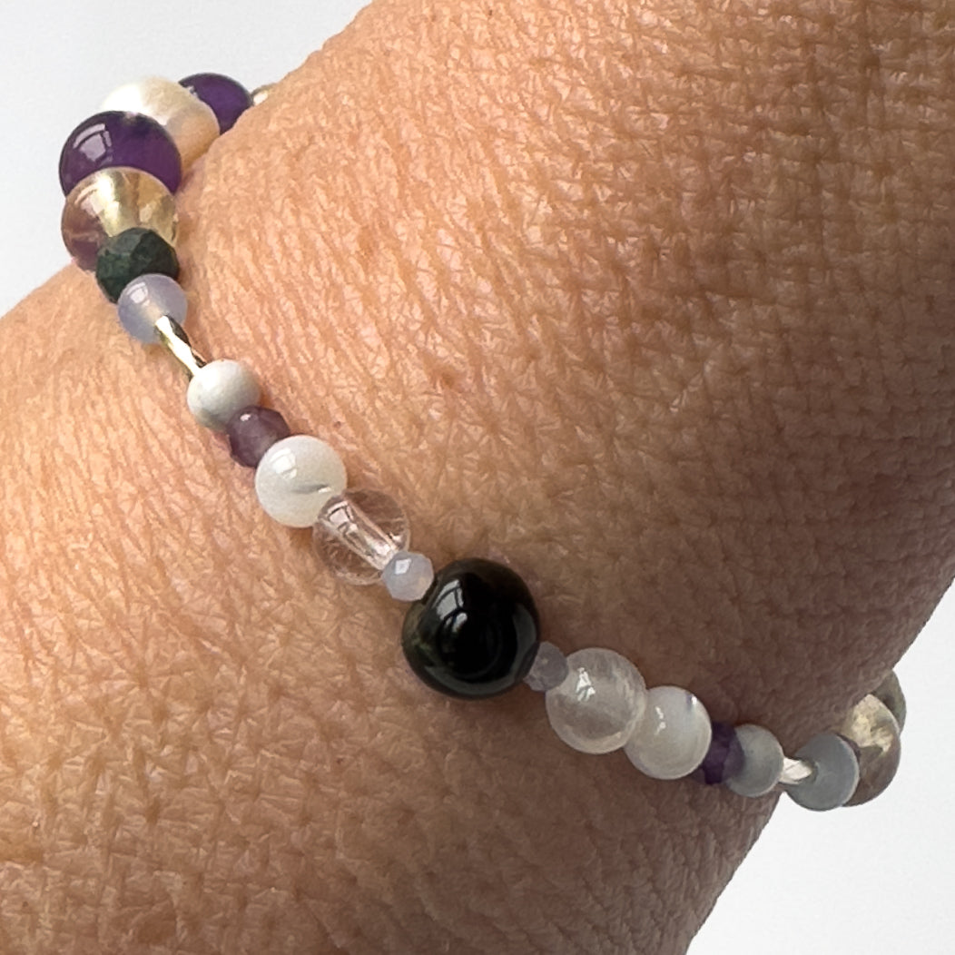 Gemini Healing Crystal bracelet for Anxiety on wrist showing Moonstone, Howlite, Blue Tiger’s Eye, Blue Lace Agate, Chrysocolla, Citrine, Amethyst, Selenite and Clear Quartz