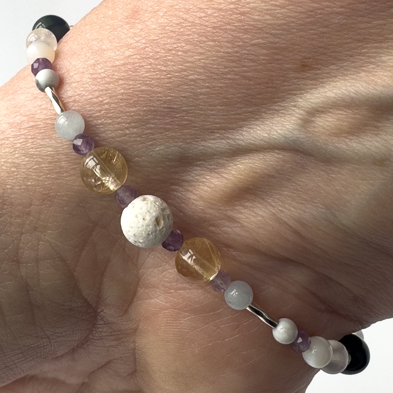 Gemini Healing Crystal bracelet for Anxiety on wrist showing Blue Lace Agate, Citrine, Amethyst and Lava Stone