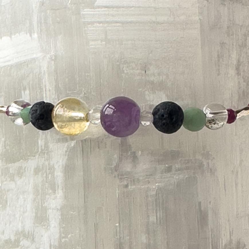 Gemini Healing Crystal bracelet for Grief & Loss showing Emerald, Citrine, Amethyst, Sugilite, Clear Quartz and Lava Stone