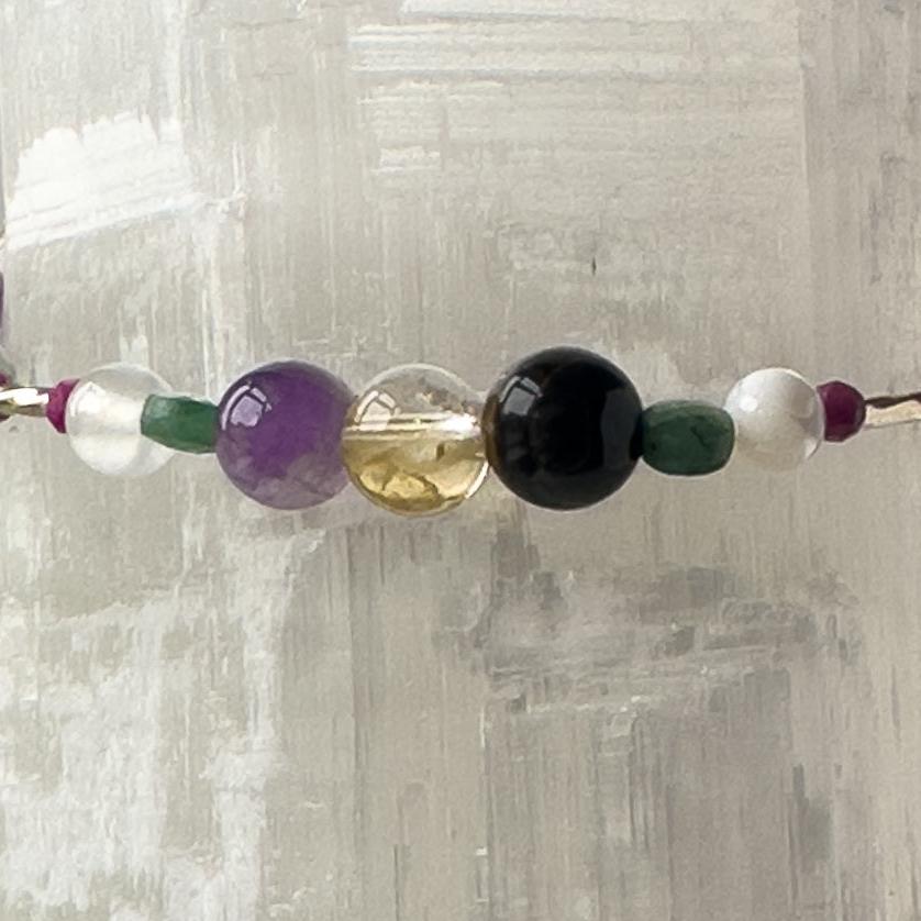 Gemini Healing Crystal bracelet for Grief & Loss showing Emerald, Moonstone, Blue Tiger’s Eye, Citrine, Amethyst, Sugilite and Selenite