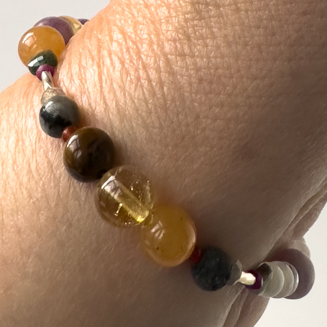 Libra Healing Crystal bracelet for Grief & Loss on wrist showing Blue Tiger’s Eye, Citrine, Labradorite, Carnelian and Lava Stone