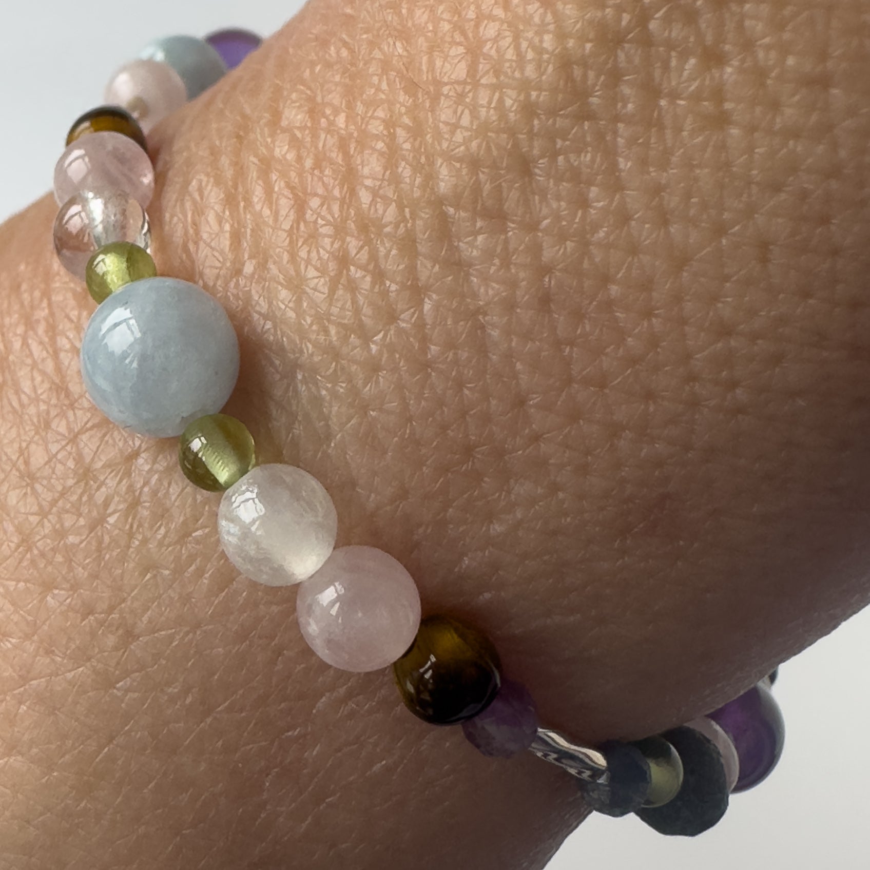 Taurus Healing Crystal bracelet for Stress on wrist showing Peridot, Aquamarine, Rose Quartz, Yellow Tiger’s Eye, Selenite and Clear Quartz