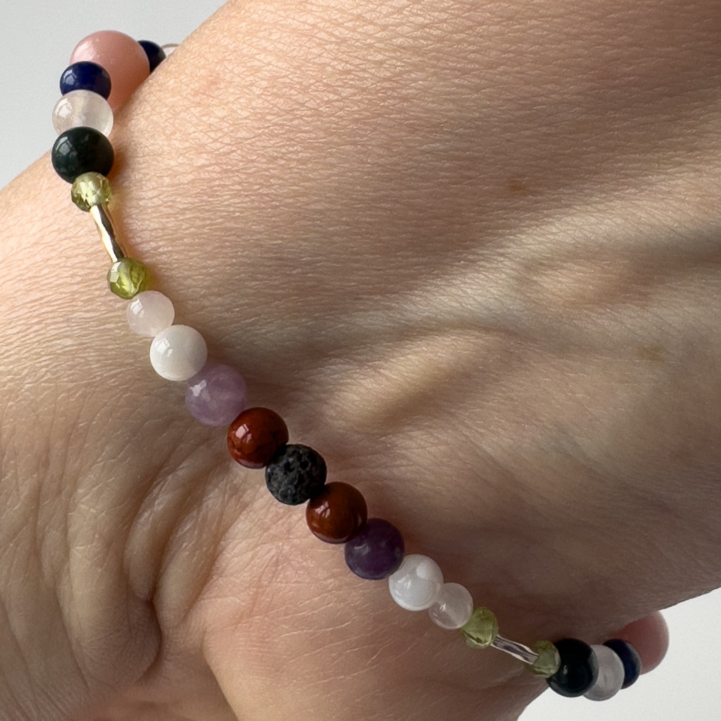 Libra Healing Crystal bracelet for Stress on wrist showing Peridot, Rose Quartz, Lepidolite, Moonstone, Jasper, and Lava Stone