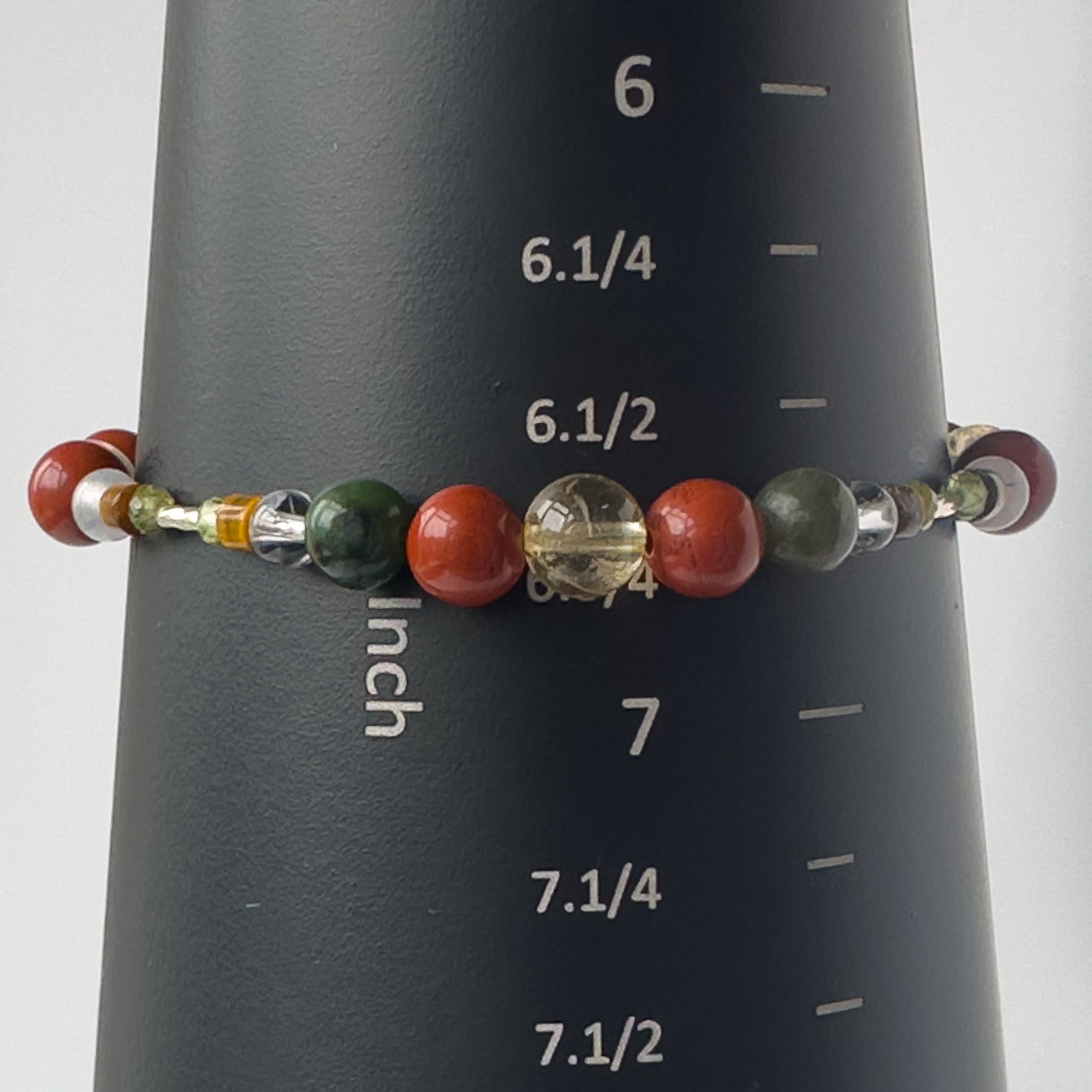 Pisces Healing Crystal bracelet for Love on mandrel showing Citrine, Jade, Red Jasper, Tiger’s Eye, Clear Quartz and size of 6.75 inches