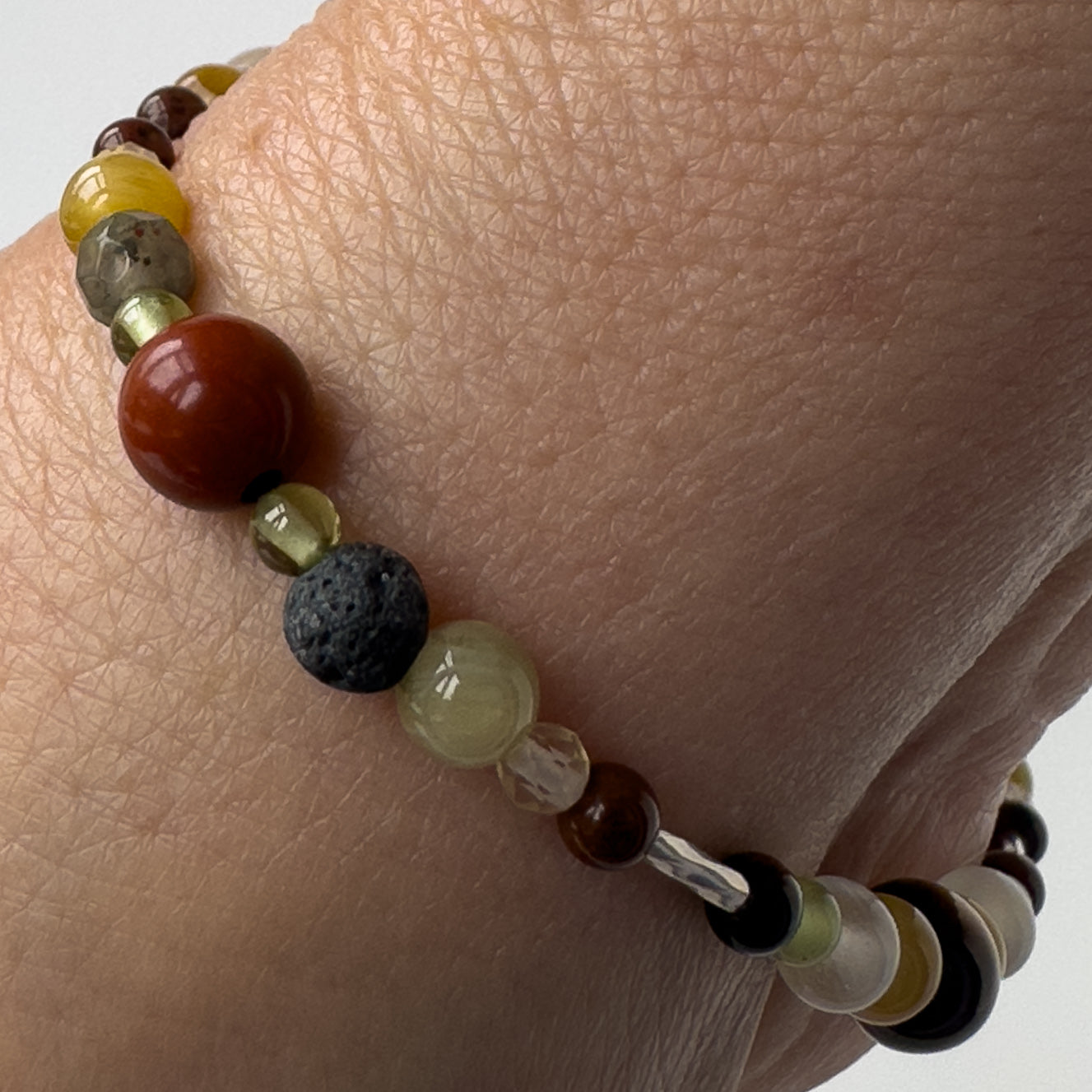 Libra Healing Crystal bracelet on wrist for Confidence showing Peridot, Bloodstone, Yellow Tiger’s Eye and Jasper