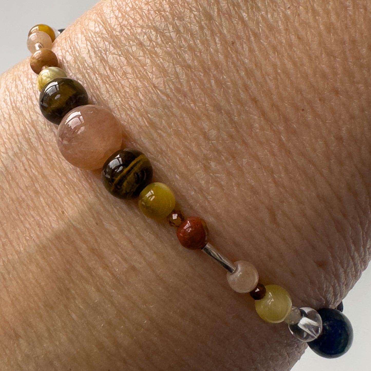Leo Healing Crystal bracelet for Confidence on wrist showing, Tiger’s Eye, Yellow Tiger’s Eye, Jasper, Garnet, Sunstone and Clear Quartz