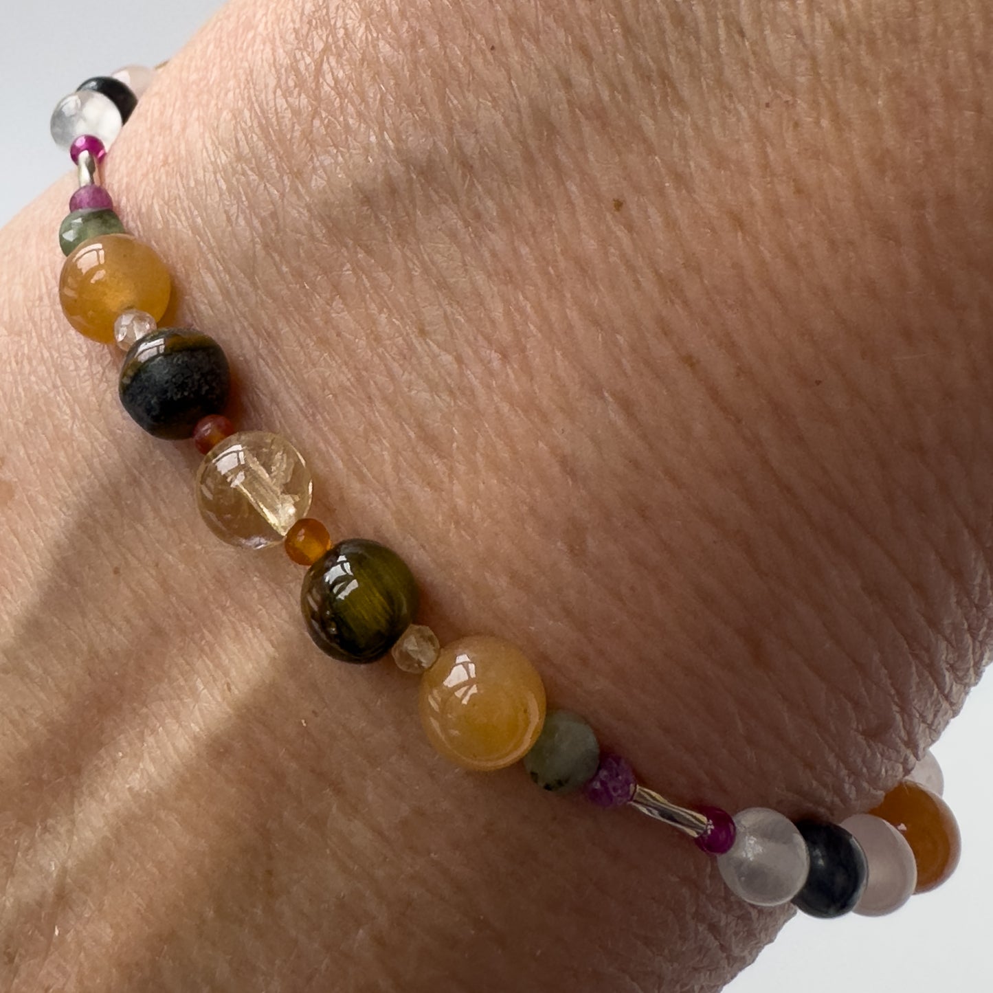 Leo Healing Crystal bracelet for Grief & Loss on wrist showing Ruby, Blue Tiger’s Eye, Carnelian, Citrine and Emerald