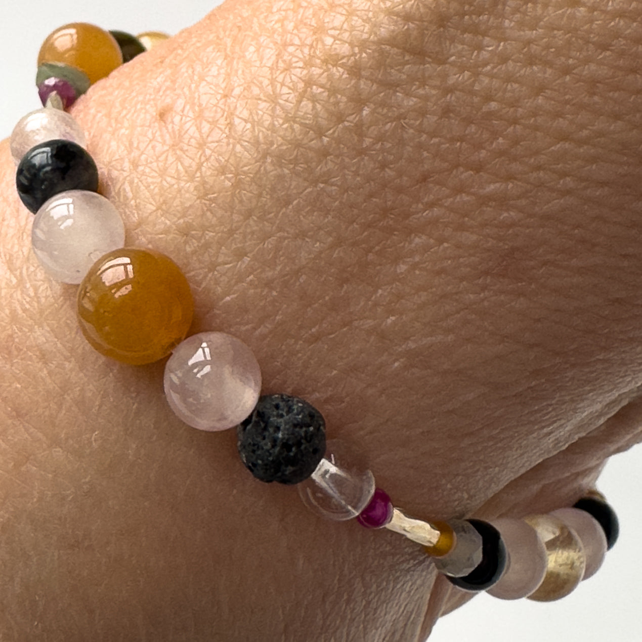 Leo Birthstone Healing Crystal bracelet for Grief & Loss support on wrist showing Ruby, Black Onyx, Rose Quartz, Carnelian, Selenite, Clear Quartz and Lava Stone
