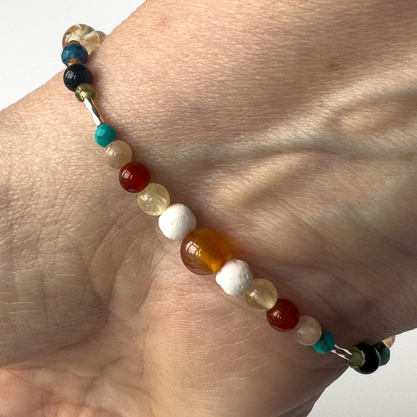 Leo Birthstone Healing Crystal bracelet for Determination & Willpower on wrist showing Carnelian, Citrine, Sunstone, Turquoise Lava Stone