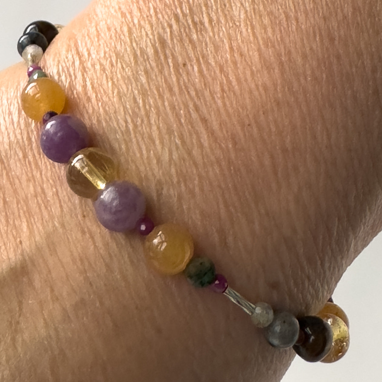 Libra Healing Crystal bracelet for Grief & Loss on wrist showing Sugilite, Citrine, Lepidolite, Carnelian and Emerald