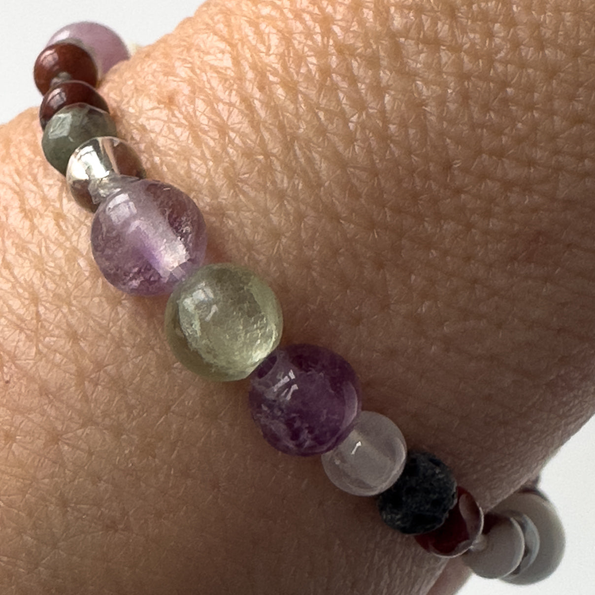 Pisces Birthstone Healing Crystal bracelet for Confidence and Self-esteem showing Bloodstone, Jasper, Fluorite, Selenite, Clear Quartz and Lava Stone on a wrist