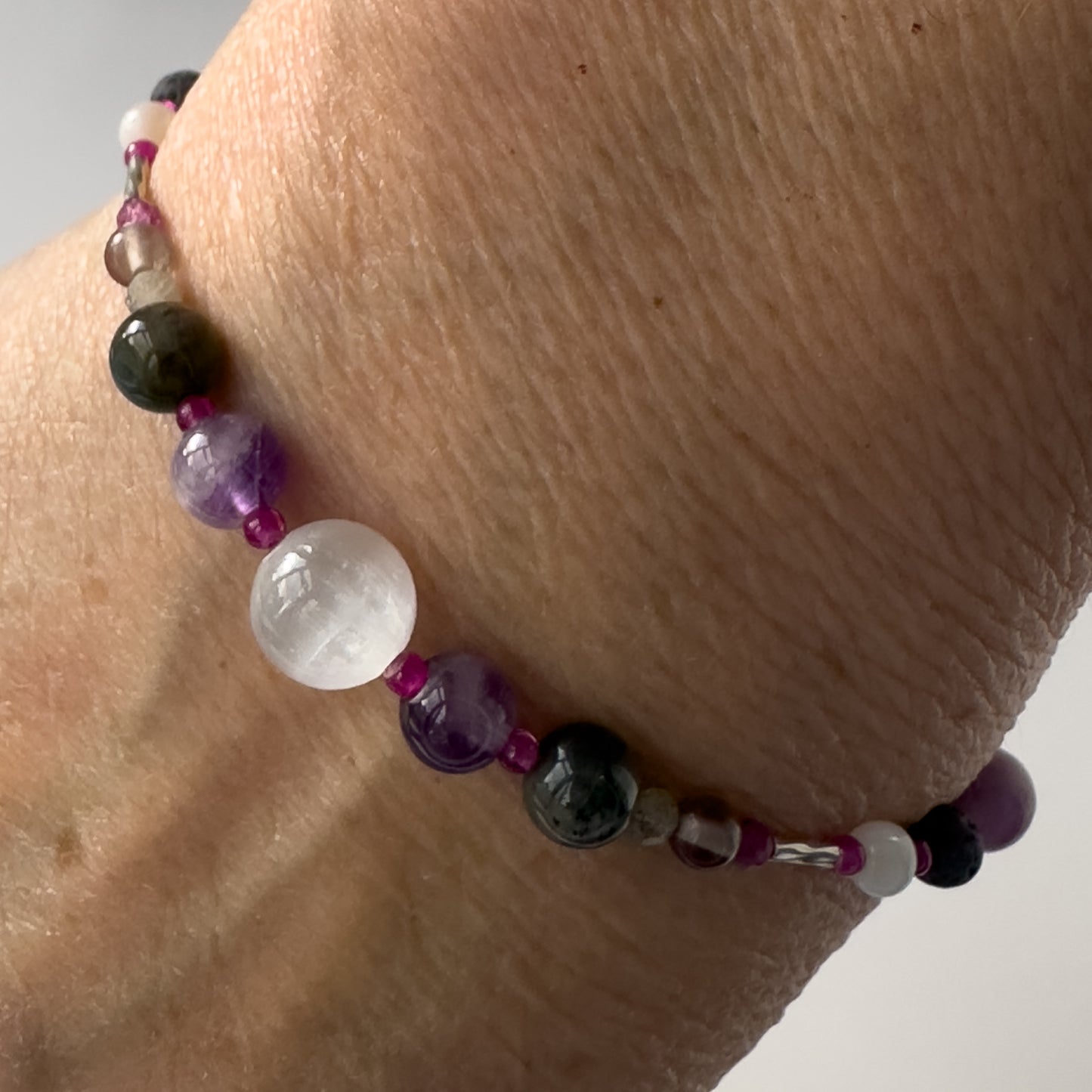 Pisces Healing Crystal bracelet for Grief & Loss on wrist showing Amethyst, Smoky Quartz, Labradorite, Ruby and Selenite
