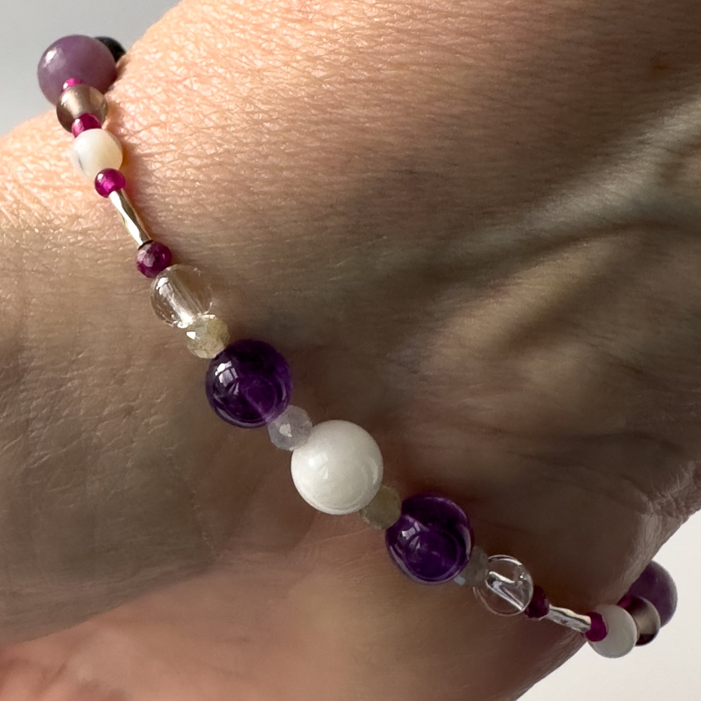 Pisces Birthstone Healing Crystal bracelet for Grief & Loss support on wrist showing Amethyst, Labradorite, Moonstone, Ruby and Clear Quartz