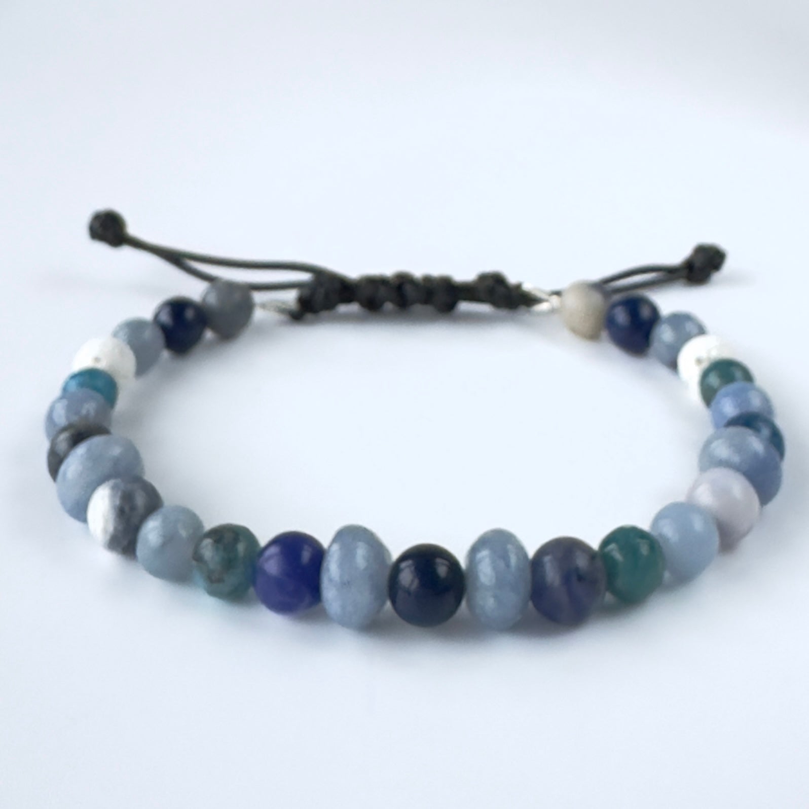 Beaded bracelet with blue and white stones on a white background