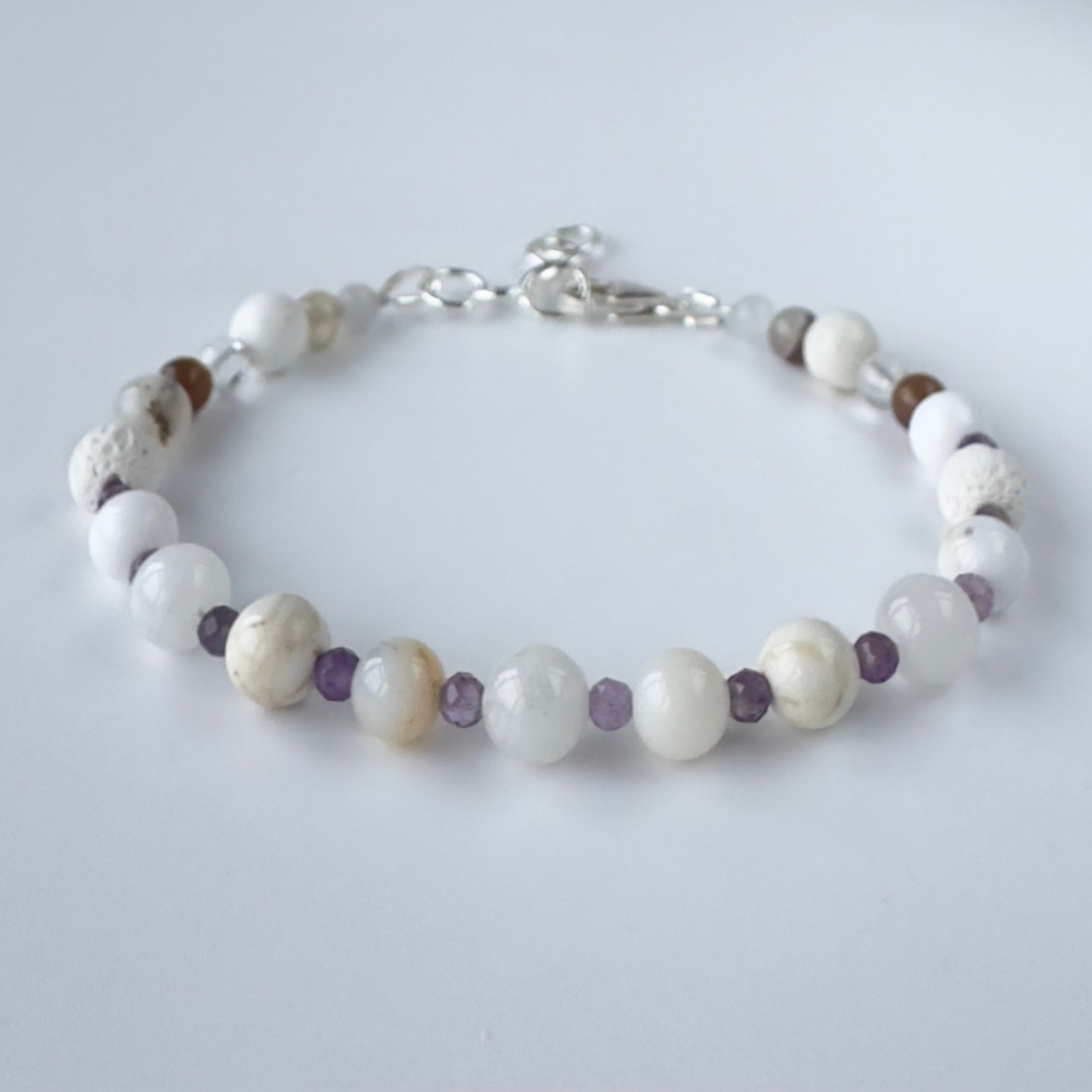 Bracelet with white and brown beads on a light gray background