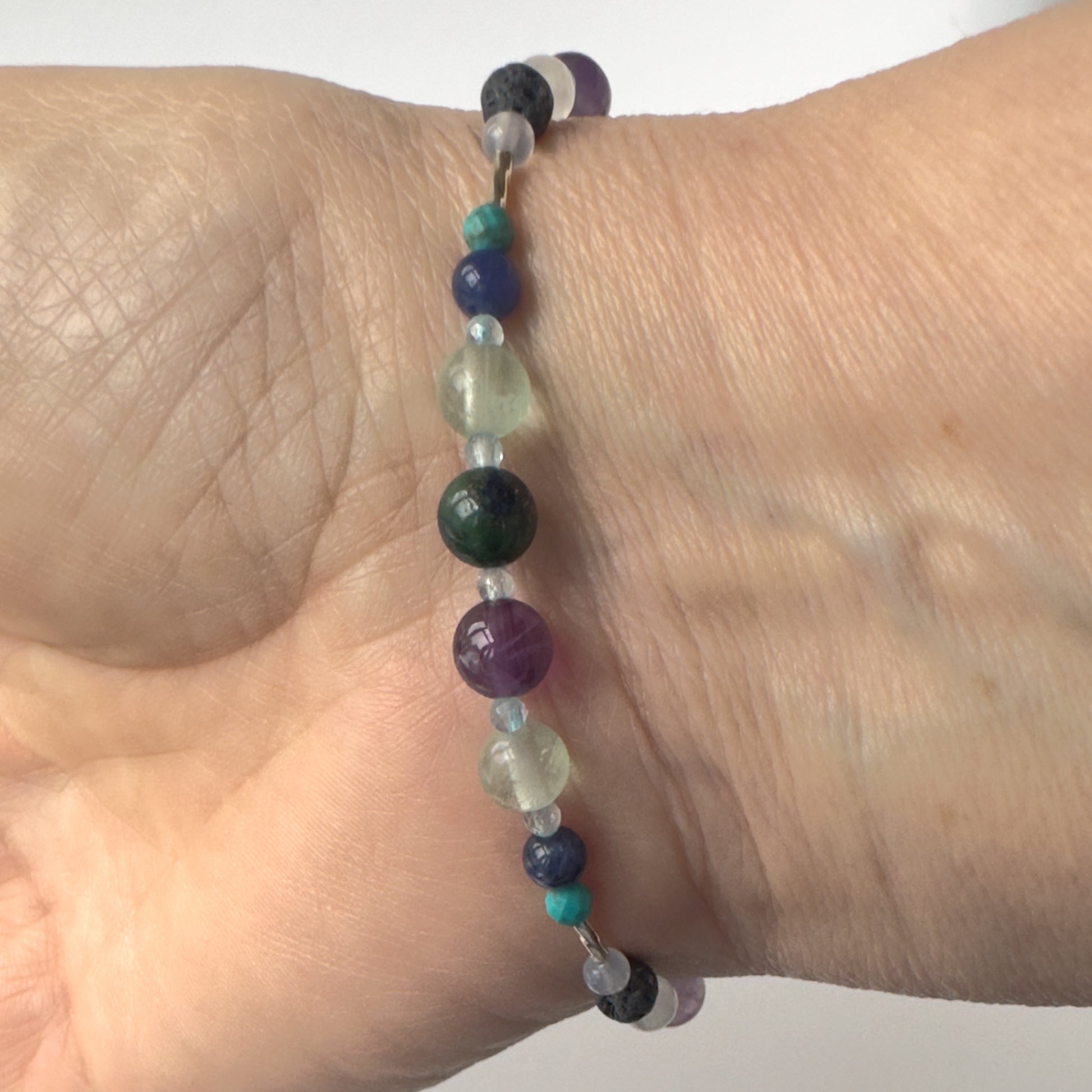 Sagittarius Birthstone Healing Crystal bracelet for Calm & Anxiety Relief on wrist showing Turquoise, Amethyst, Lapis Lazuli, Azurite, Blue Topaz, Fluorite and Blue Lace Agate 