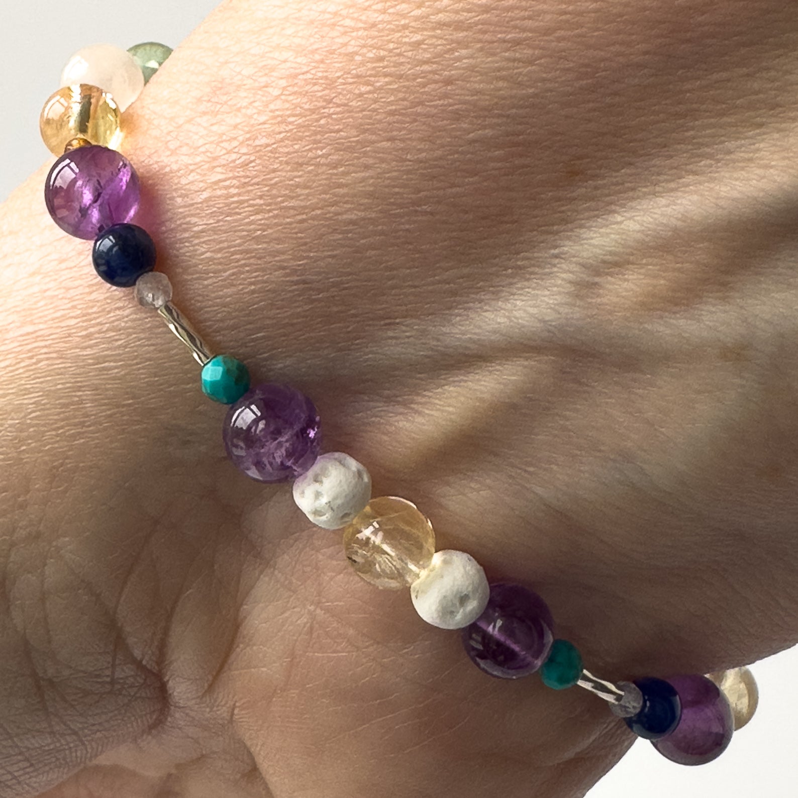 Sagittarius Birthstone Healing Crystal bracelet for Determination & Willpower on wrist showing Amethyst, Citrine, Turquoise and Lava Stone