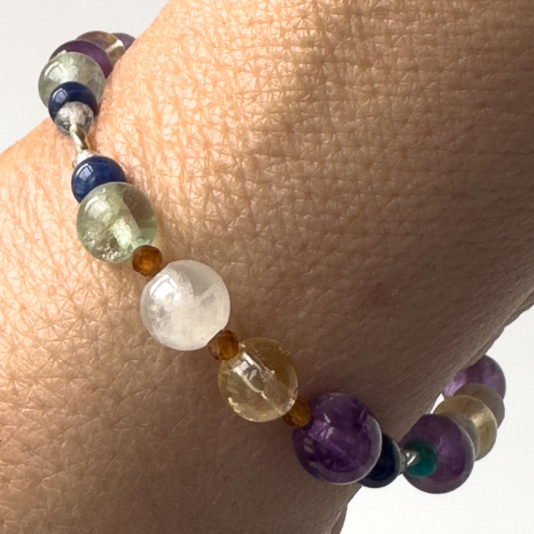 Sagittarius Birthstone Healing Crystal bracelet for Determination & Willpower on wrist showing Amethyst, Rainbow Fluorite, Citrine, Sodalite, Garnet and Selenite
