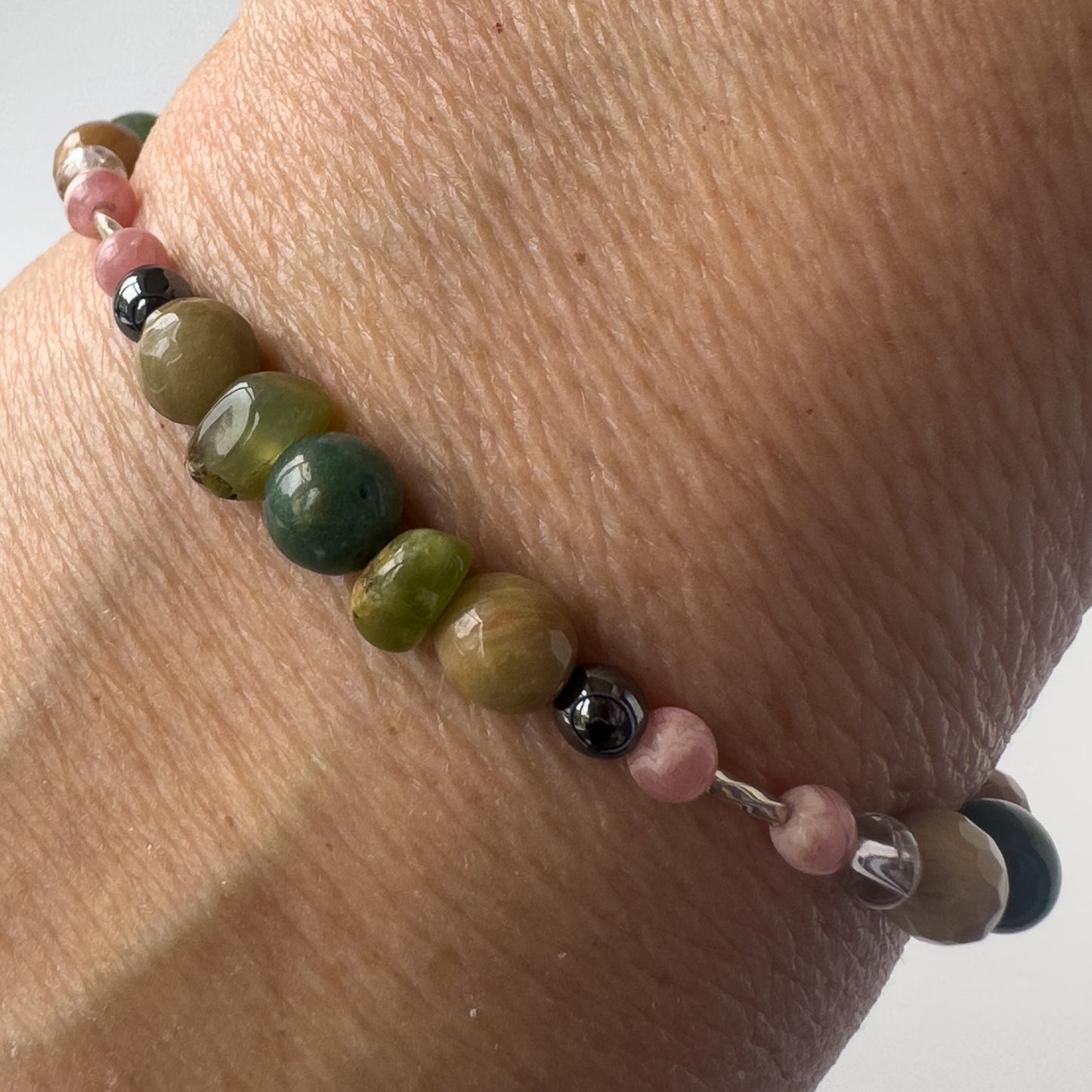 Scorpio Healing Crystal bracelet for Love on wrist showing Hematite, Moss Agate, Chrysoprase, Rhodochrosite and Rhodonite