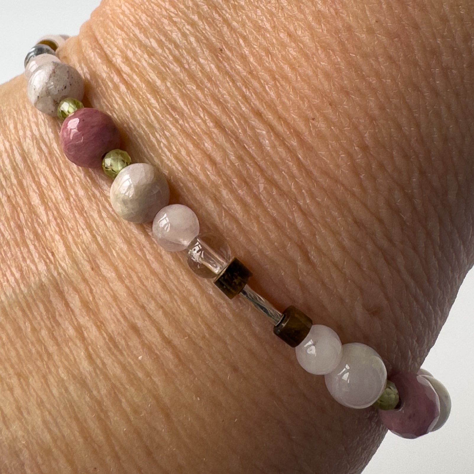 Taurus Healing Crystal bracelet for Love on wrist showing Rose Quartz, Peridot, Kunzite, Rhodonite, Tiger’s Eye and Selenite